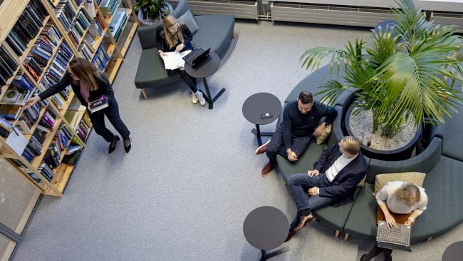 Vaisala employees working and talking in the office