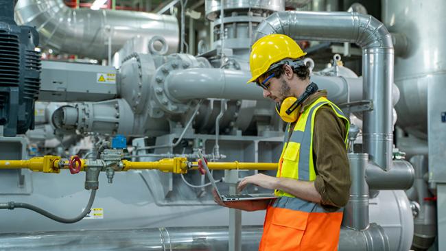 Engineer using laptop computer working in thermal power plant