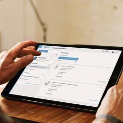 Person holding tablet with Jade Smart Cloud user interface.